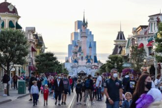 Famille heureuse devant le château de Disneyland Paris