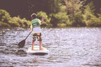 Planche de surf colorée avec accessoires sur un fond de plage ensoleillée