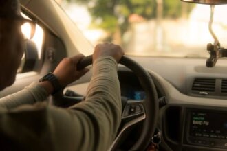 Conducteur examinant des documents d'assurance auto dans une voiture garée