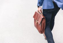 person walking holding brown leather bag