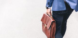 person walking holding brown leather bag