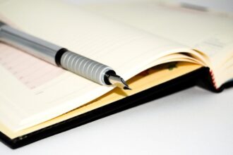 Stylos variés sur un bureau avec des fournitures scolaires