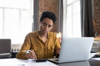 étudiant examinant des brochures d'assurance dans un appartement lumineux et moderne