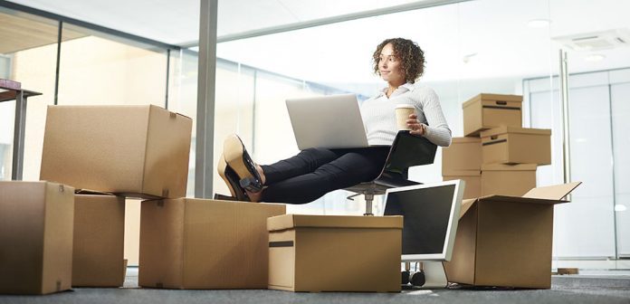 Une femme finalisant ses cartons de déménagement commercial