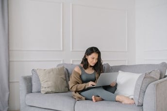 Une femme sur un canapé avec son ordinateur