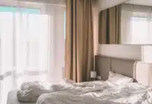 white bed linen near white window curtain