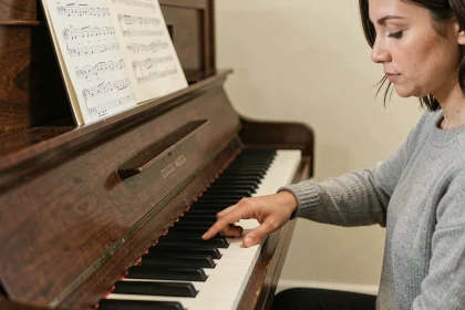 Femme appuyant sur le si bémol d'un piano droit, focus sur la touche noire et le clavier