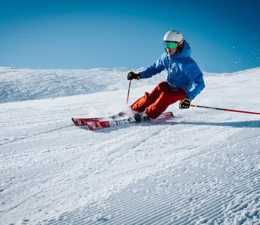 man ice skiing on hill