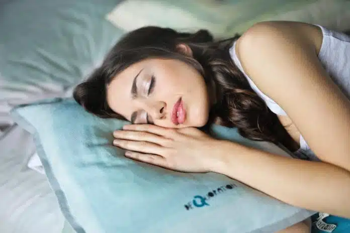Une femme qui dort sur un oreiller fin bleu