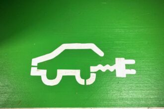 Voiture électrique moderne stationnée devant un bâtiment professionnel