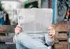 un homme sur un banc lisant son journal