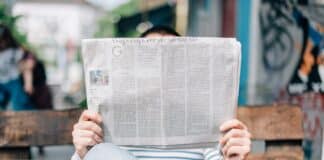 un homme sur un banc lisant son journal
