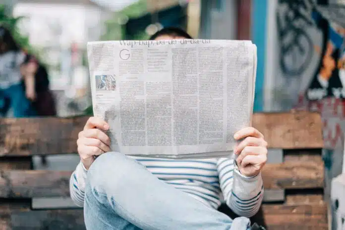 un homme sur un banc lisant son journal