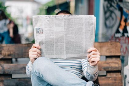 un homme sur un banc lisant son journal